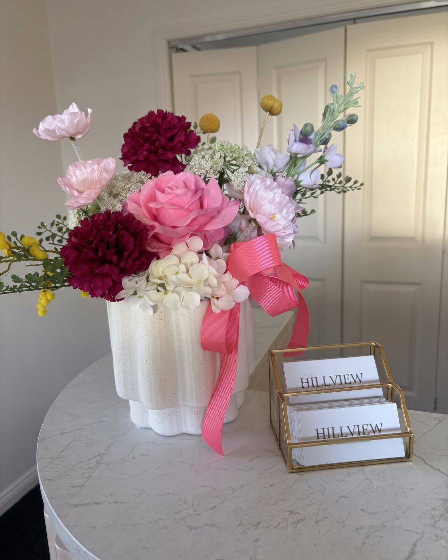 Flowers and Hillview Aesthetics cards on the reception desk